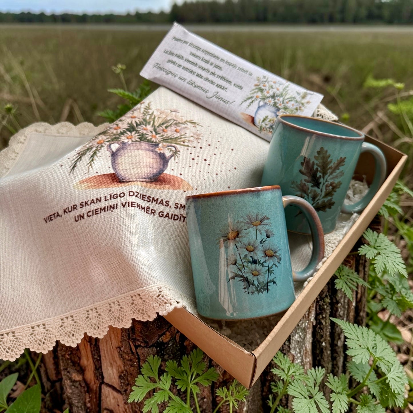 Jāņu dāvanu komplekts ar divām keramikas krūzēm, personalizētu šokolādi un galdautiņu pļavas stilā kastītē | Zelta Pūka